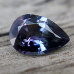 Angled view of natural purple spinel showing pear-cut facets and polish