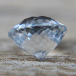 Ceylon white sapphire round cut gemstone showing slight blue tint and faceting