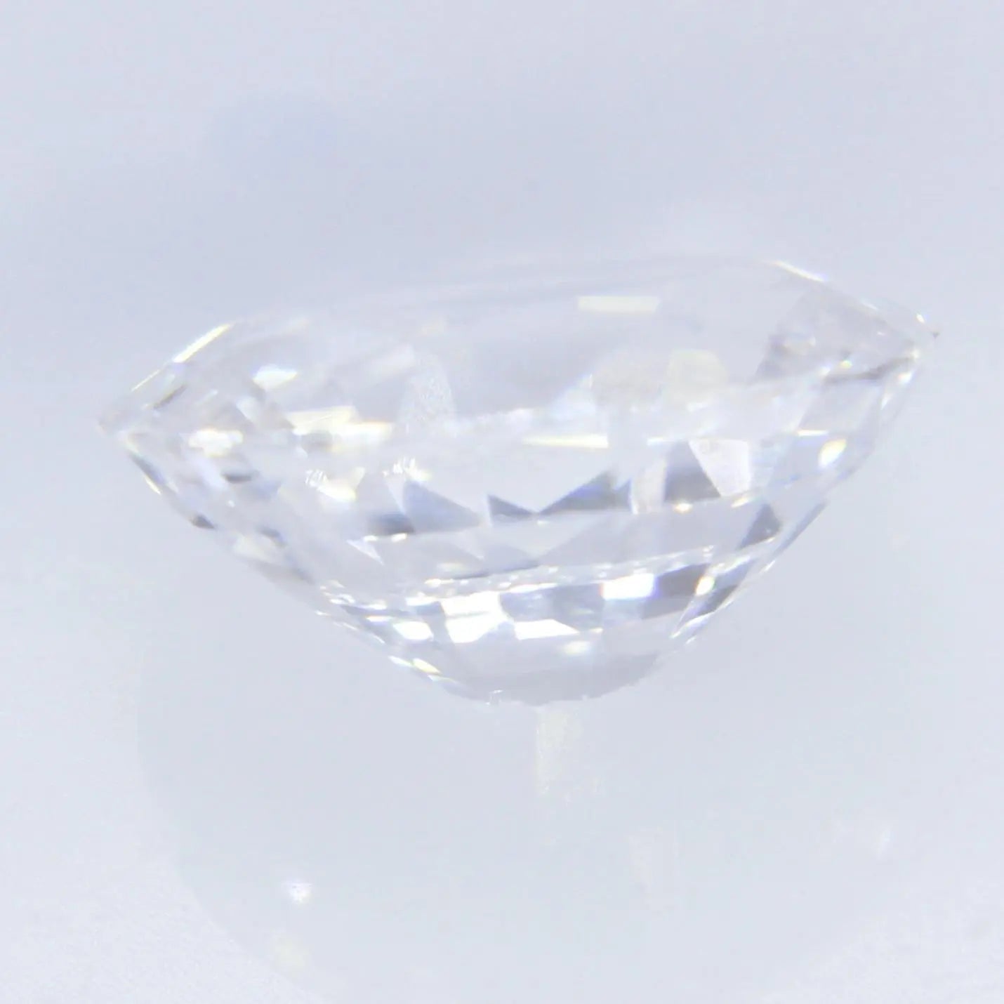 Side profile of oval white sapphire showing 3.13 mm depth, faceted gemstone