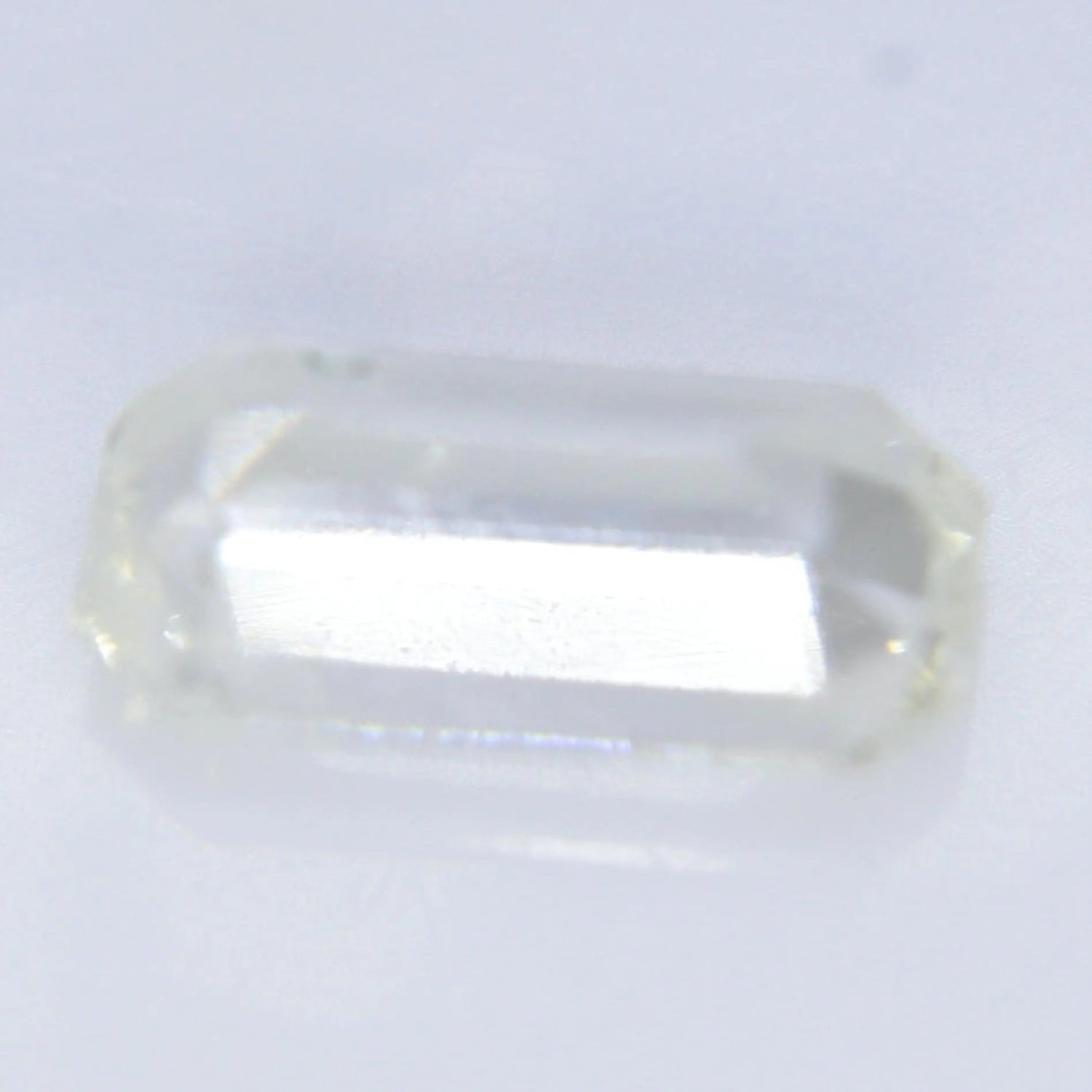 Untreated white sapphire emerald cut gemstone with slight yellow tone
