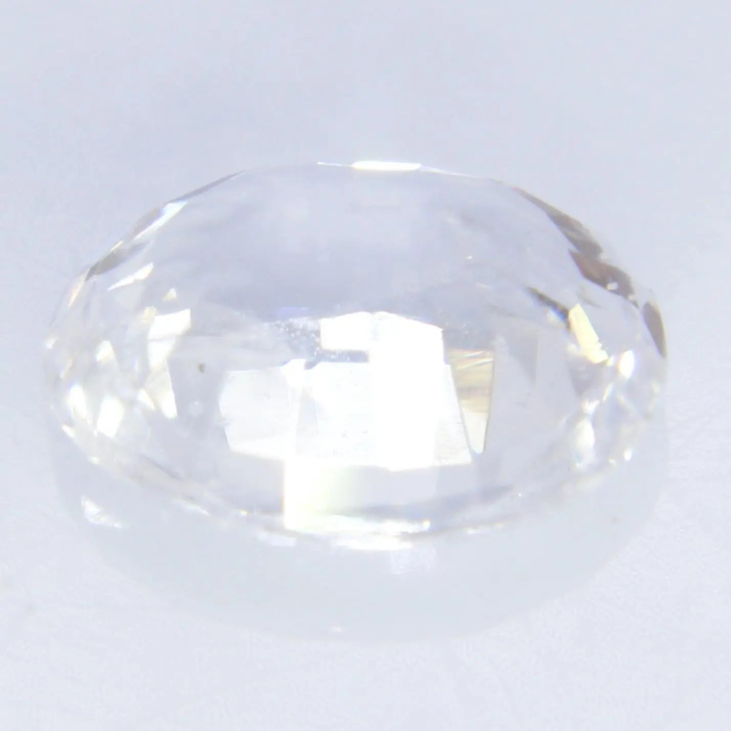 Macro of earth-sourced white sapphire oval cut — clean facets and luster