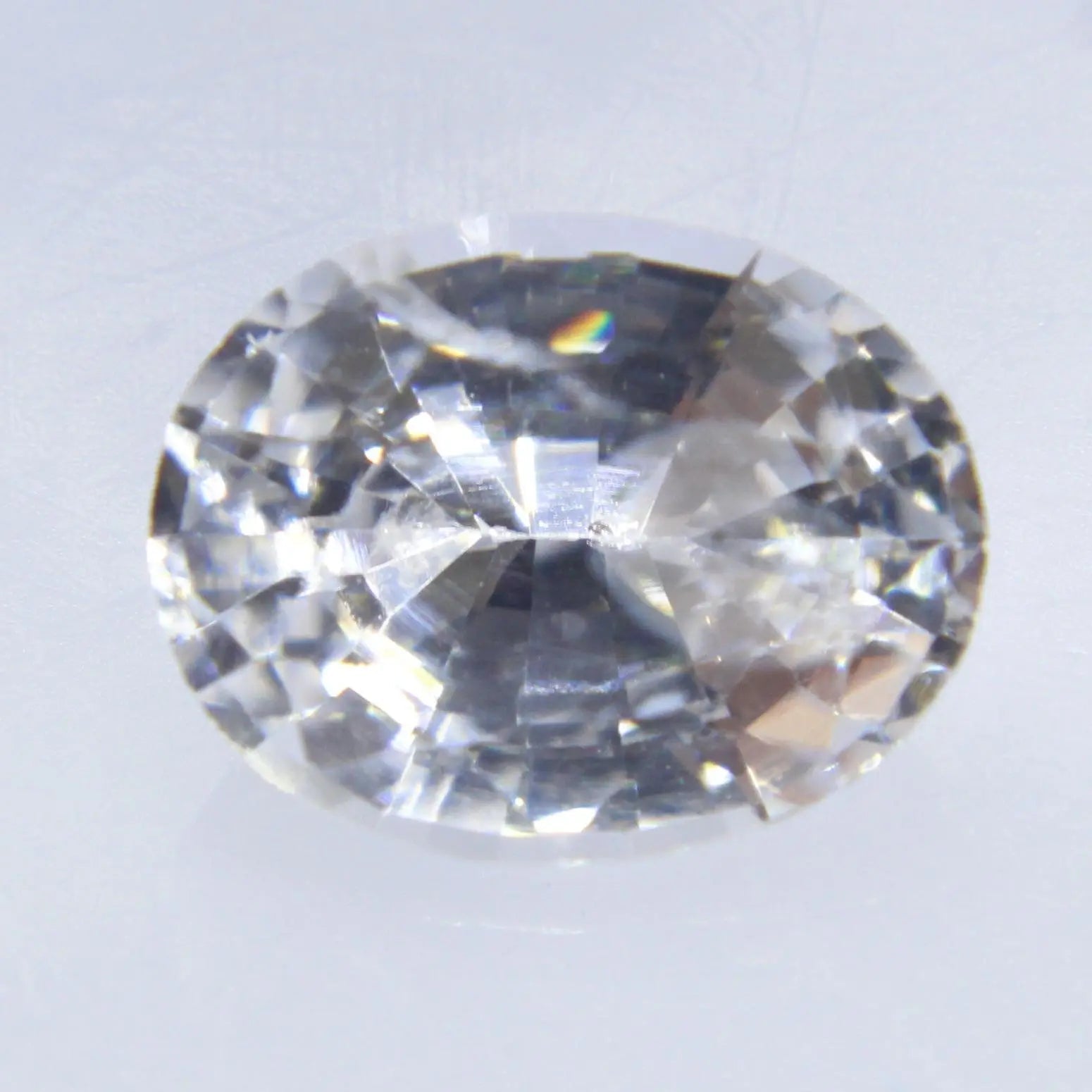 Face-up view of white sapphire 6.23 × 4.90 mm with bright scintillation