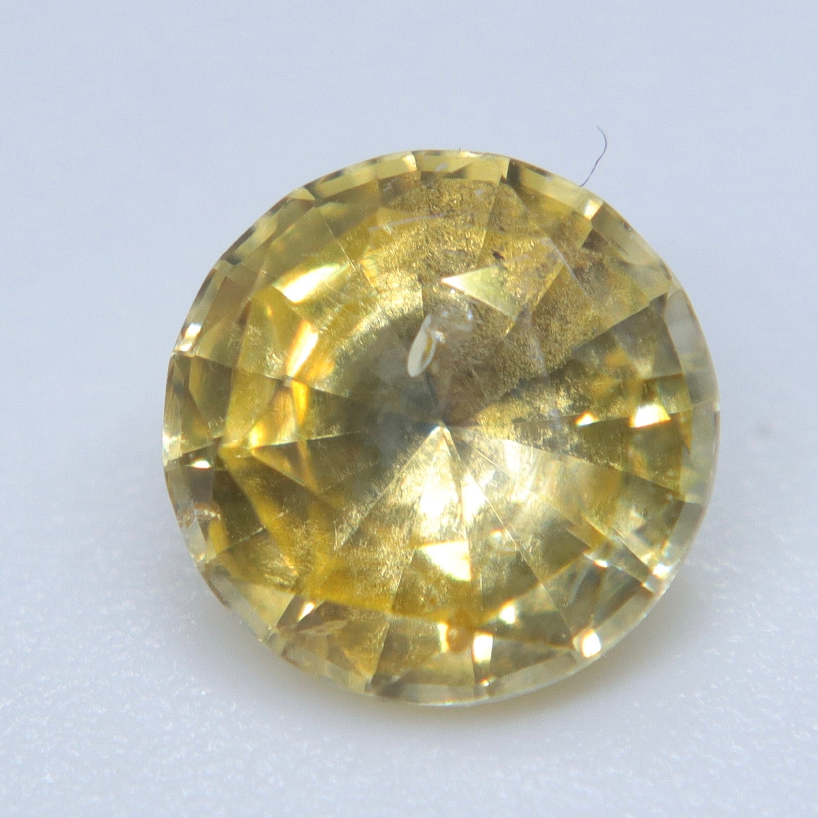 Pavilion view of natural 1.20ct yellow sapphire showing its faceting and inclusions