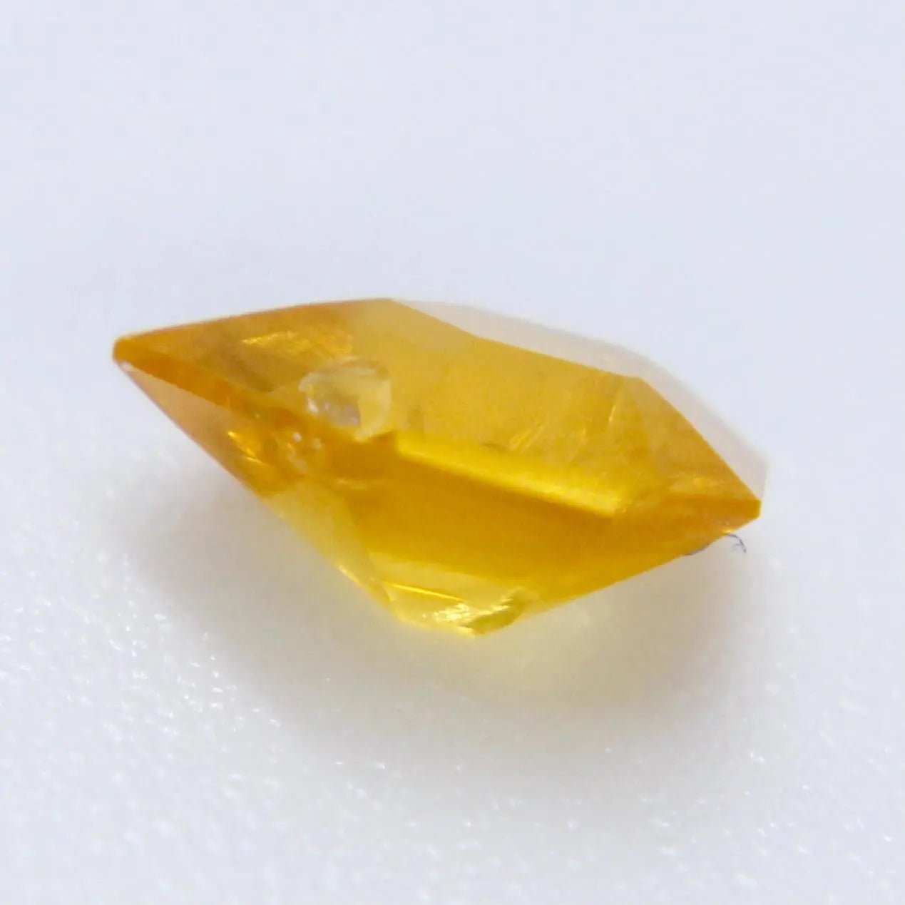 Freeform yellow sapphire with calipers: 5.67 × 4.55 × 2.81 mm