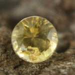 Round faceted yellow sapphire on gem tray, untreated