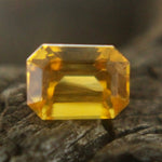 Natural yellow sapphire showing step-cut facets and brilliance — loose gemstone