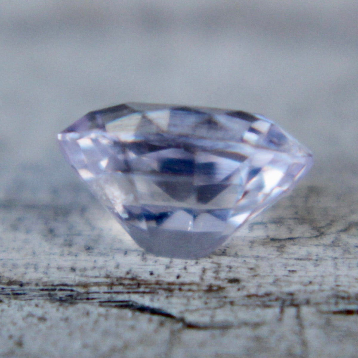 Side profile of a pale purple emerald-cut sapphire
