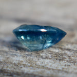 Close-up of the table and surrounding facets of a blue-green pear sapphire