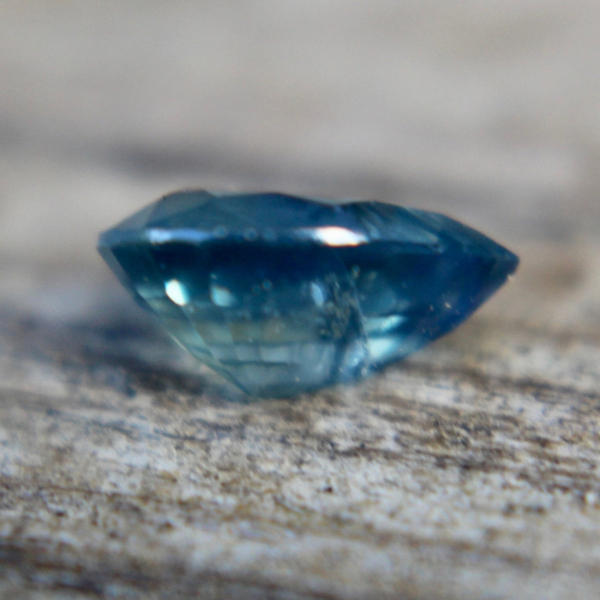 Close-up of the table and surrounding facets of a blue-green pear sapphire