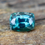 Underside view of a teal green sapphire showing its pavilion facets