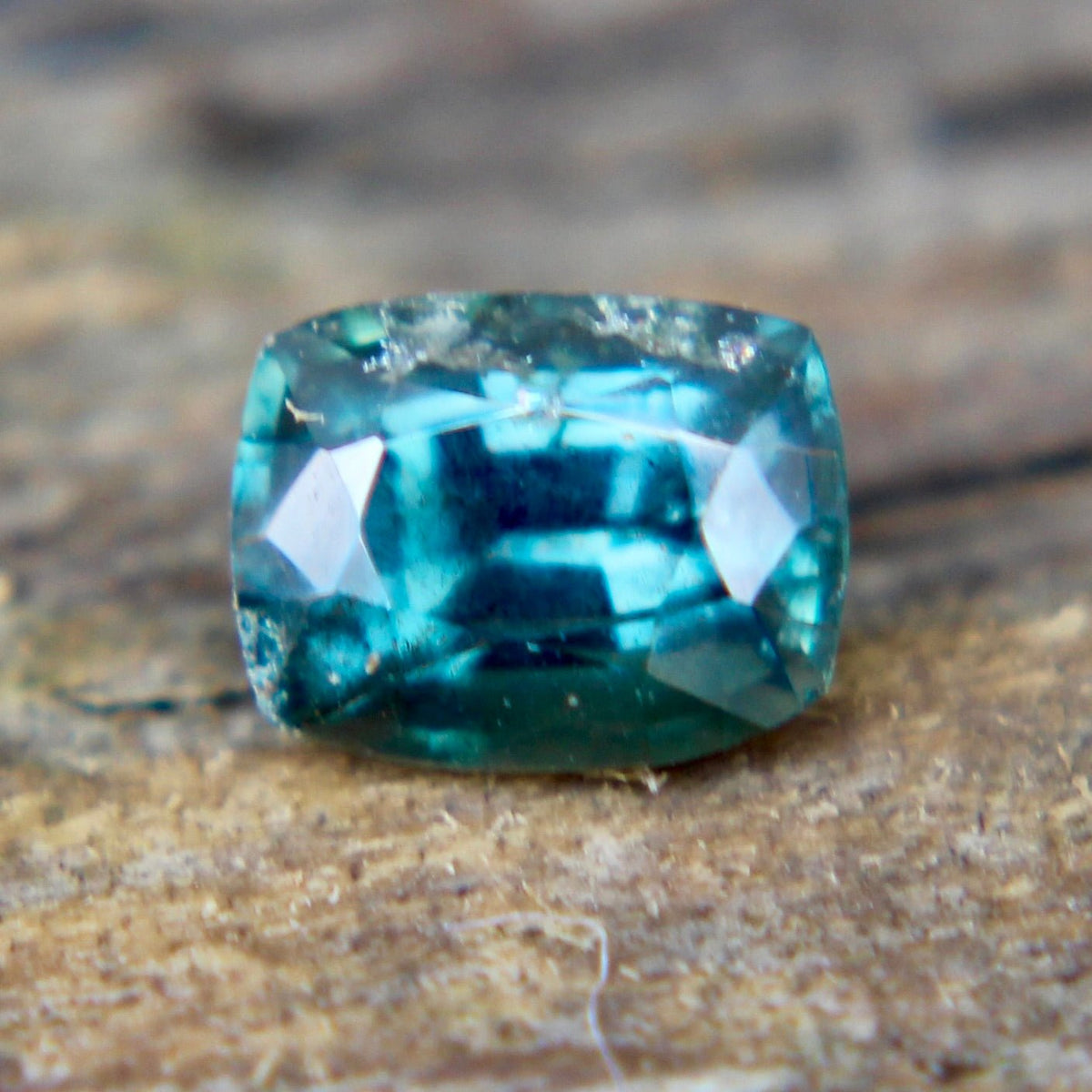 Underside view of a teal green sapphire showing its pavilion facets
