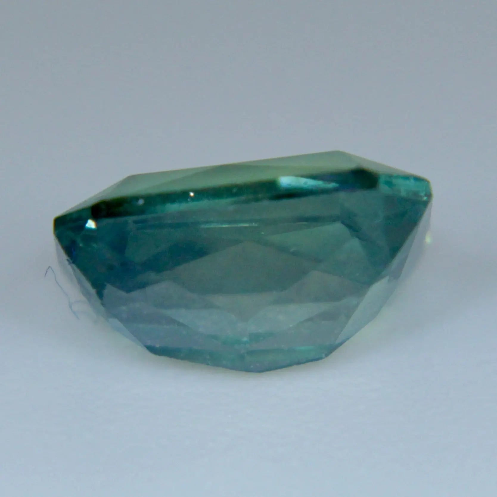 Unheated natural green sapphire showing tapered emerald-cut facets