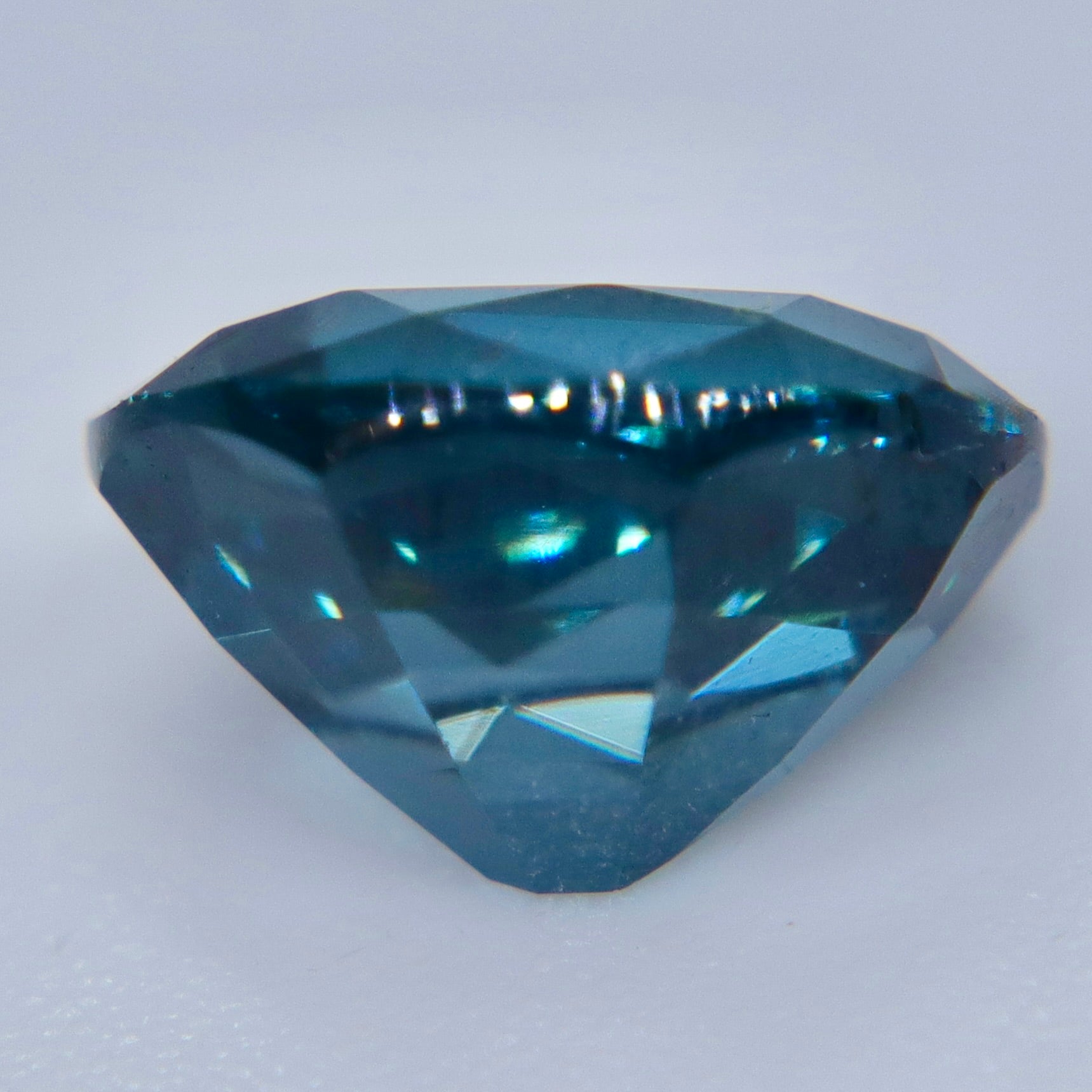 Side profile of an untreated oval teal blue spinel from Ceylon