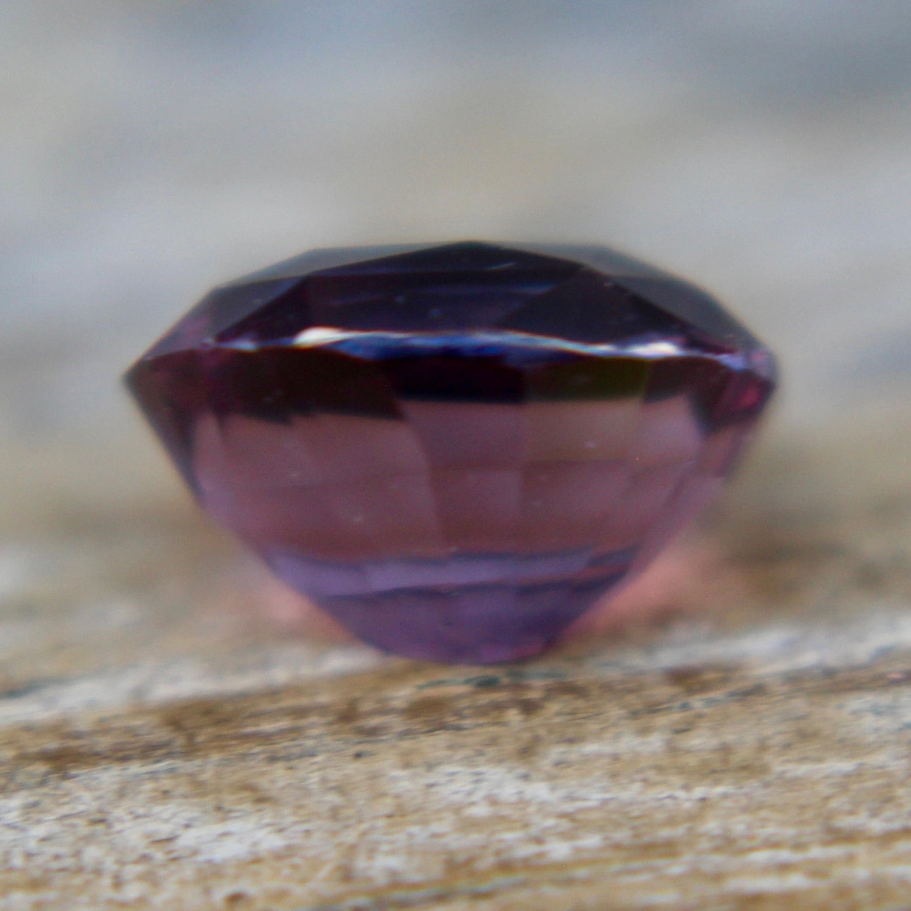 Side profile of an untreated purple sapphire measuring 7.00 by 5.71 mm