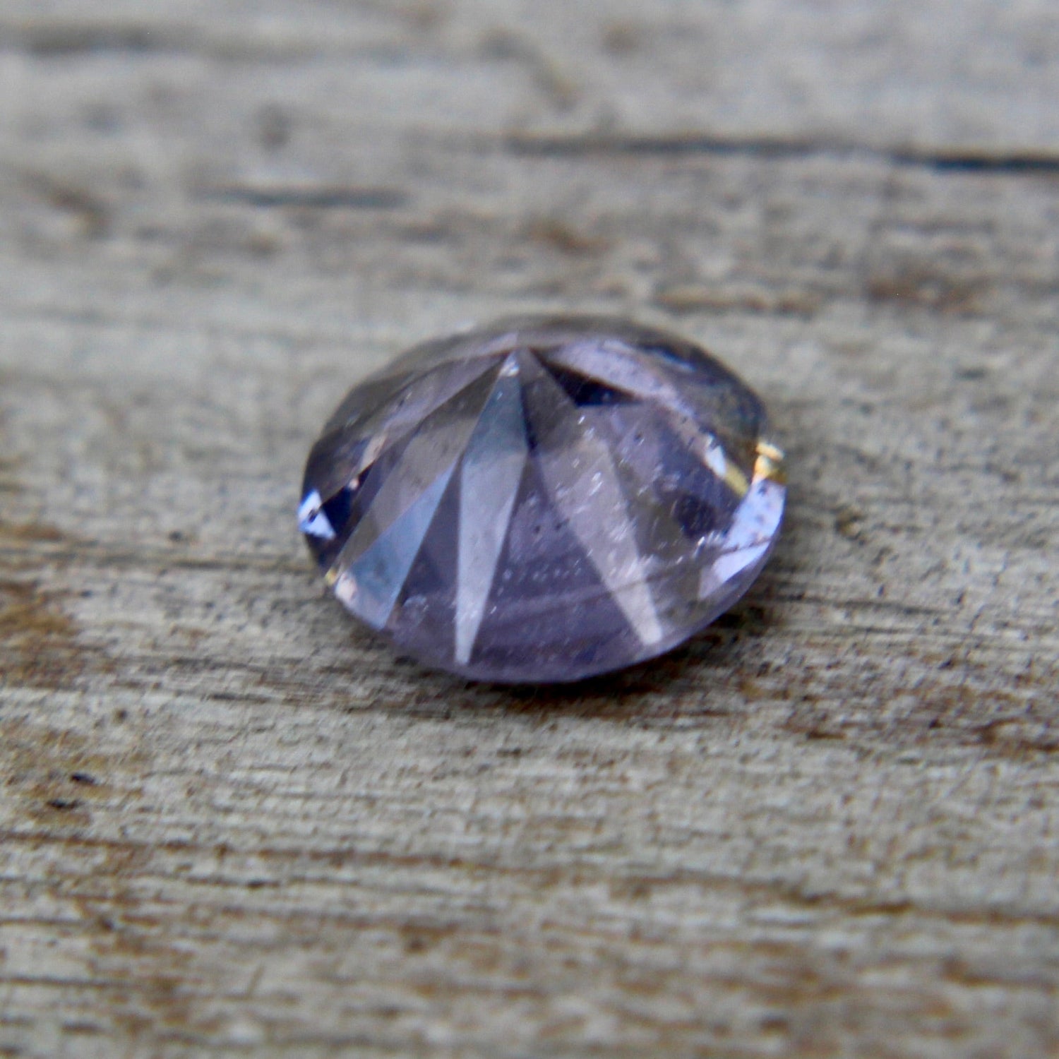 Face-up view of untreated 0.89 carat round purple spinel gemstone