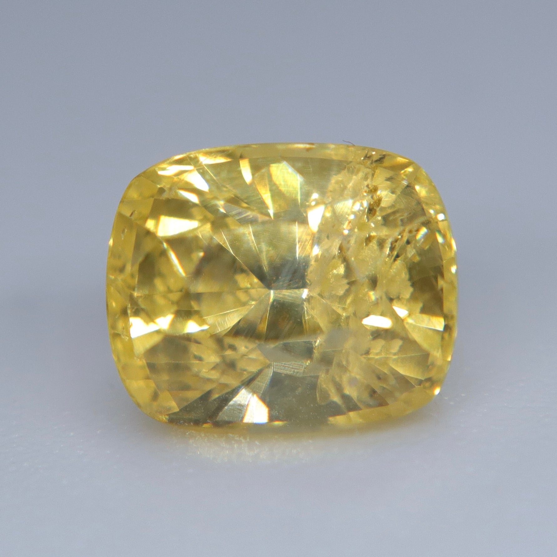 Loose vivid yellow sapphire measuring approximately 6.42 by 5.31 mm