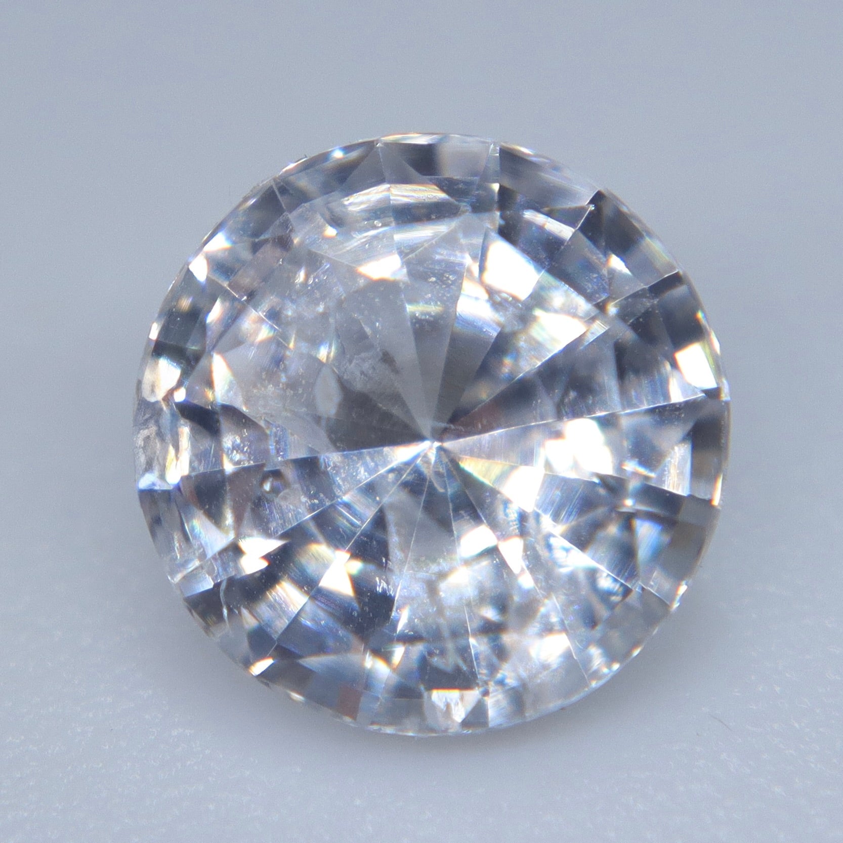 Loose white sapphire measuring approximately 6.81 mm in diameter