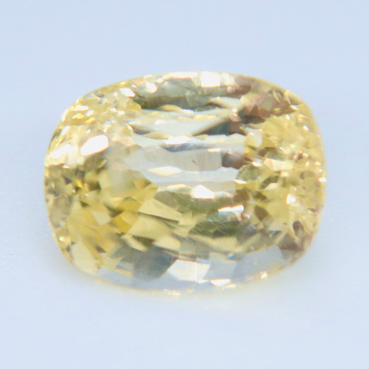 Close-up of the yellow cushion sapphire showing reflections and fine internal details